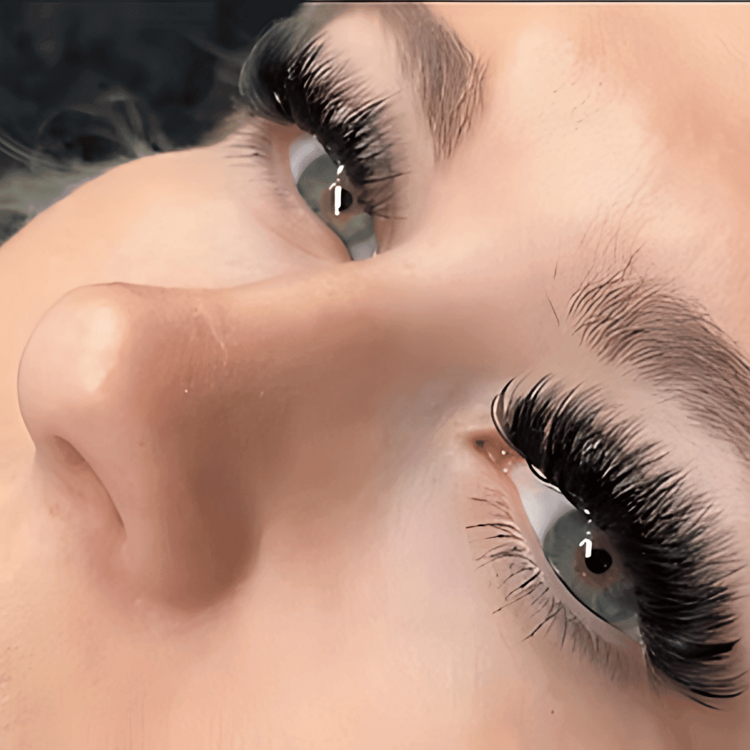 Close-up of a person's eyes with long, thick eyelashes, looking upwards.