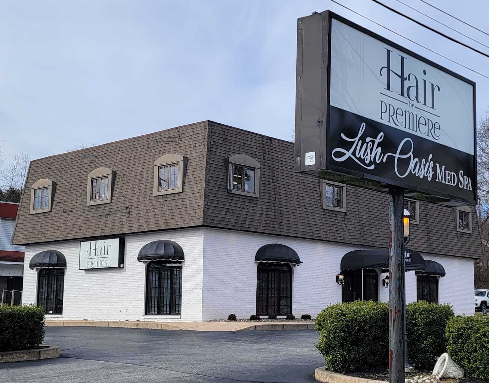 Exterior of Hair Premiere Lush Oasis Med Spa with signage and parking lot in view.